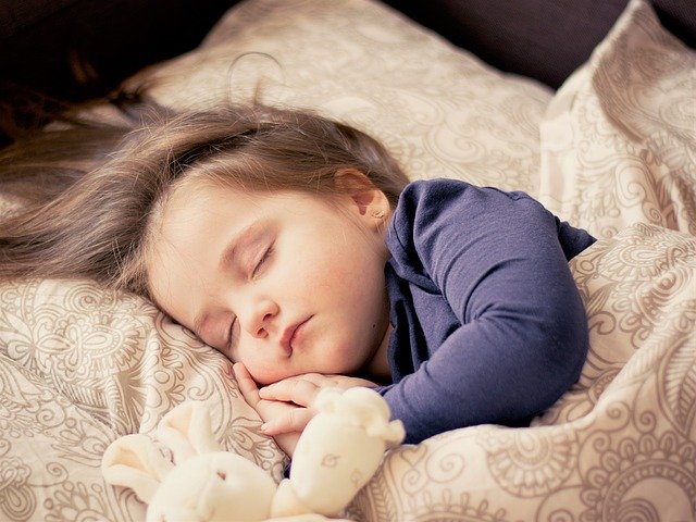 dítě spící s plyšákem